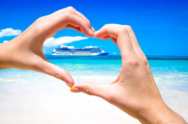 Cruise ship in the sea near the tropical island inside hands making heart shape. — Stock Photo, Image
