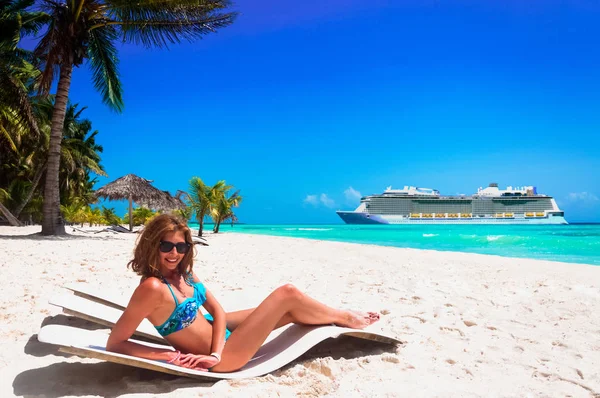 Concept de vacances de croisière. Bateau de croisière dans la mer près de l'île tropicale avec une femme couchée sur un lit de plage près de la mer. Détente et plaisir en vacances . — Photo