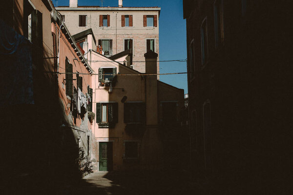 The sun is creating a light and shadow scene on houses in Venice, Italy