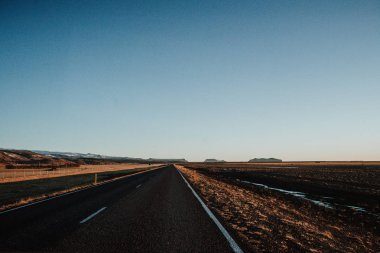 İzlanda'daki bazı dağlar doğru günbatımında önde gelen bir yol