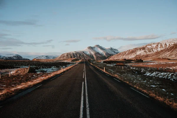 日落时通往冰岛一些山脉的笔直道路 — 图库照片