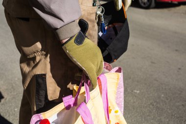 Adamın elinde bir alışveriş çantası var. İş üniforması eldivenini teslim et.