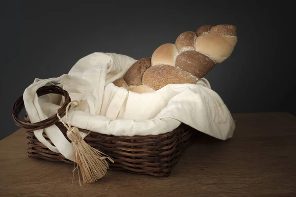 Pleciony chleb w wiklinowym koszu na stole — Zdjęcie stockowe