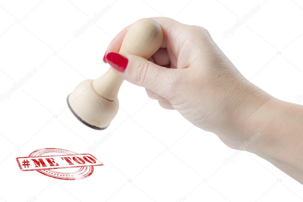Hand holding a rubber stamp with the hashtag me too