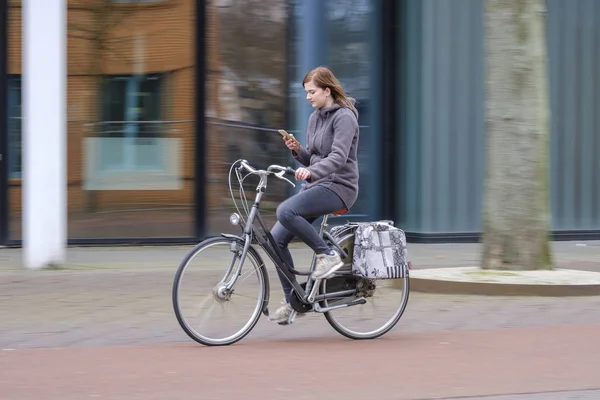 Kız bir bisiklet sürme ve onun smartphone vasıl tehlike görünüyor