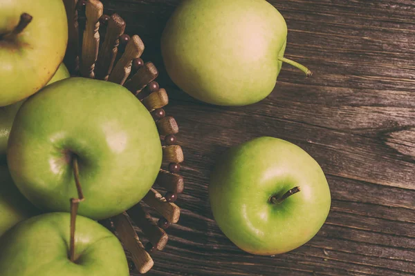 Manzanas verdes maduras y rodajas de manzana sobre fondo gris madera — Foto de Stock