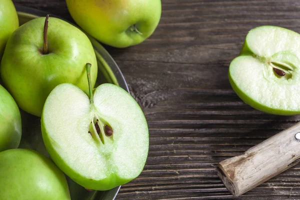Manzanas verdes maduras y rodajas de manzana sobre fondo gris madera — Foto de Stock