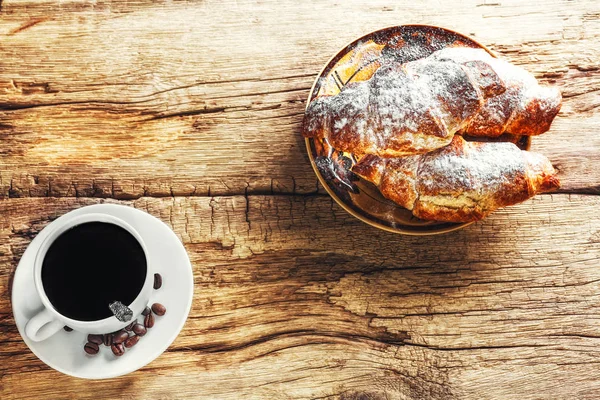 Café e croissant em fundo de madeira — Fotografia de Stock