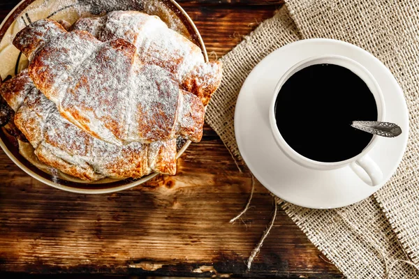 Café e croissant para café da manhã em mesa de madeira rústica, top v — Fotografia de Stock