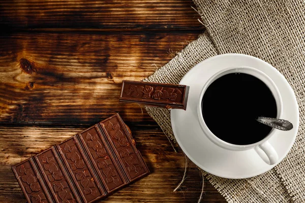 Xícara de café e feijão, paus de canela, nozes e chocolate na woo — Fotografia de Stock