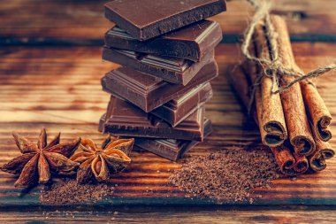 kırılmış çikolata bar ve baharat ahşap masa üstünde. seçici odak