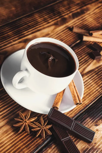 Xícara de chocolate quente, paus de canela, nozes e chocolate no woo — Fotografia de Stock