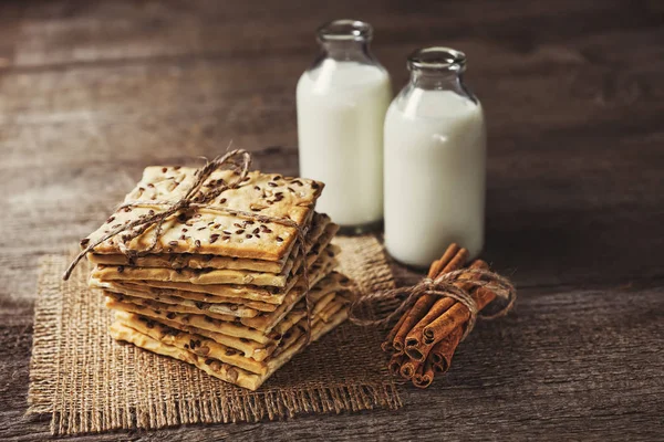 Knuspriger Diätcracker mit Müsli und Milch auf dunklem Holz — Stockfoto
