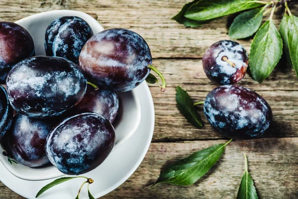 Fresh plums with leaveson a dark wood background. toning. select — Stock Photo, Image