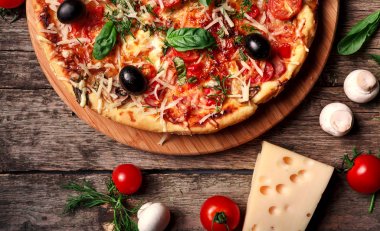 Tahta masada domatesli, peynirli ve mantarlı taze pizza.