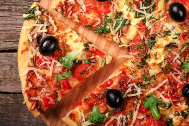 Tahta masada domatesli, peynirli ve mantarlı taze pizza.