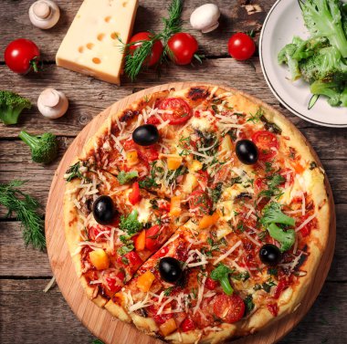 Tahta masada domatesli, peynirli ve mantarlı taze pizza.