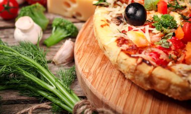 Tahta masada domatesli, peynirli ve mantarlı taze pizza.