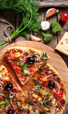 Tahta masada domatesli, peynirli ve mantarlı taze pizza.