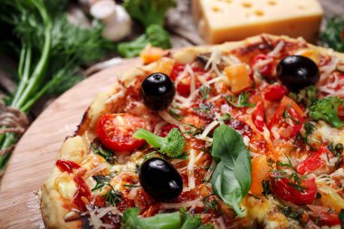 Tahta masada domatesli, peynirli ve mantarlı taze pizza.