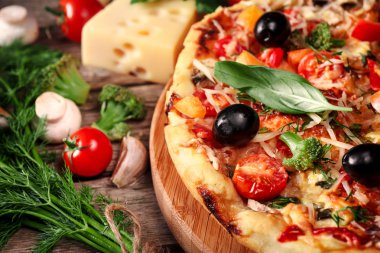 Tahta masada domatesli, peynirli ve mantarlı taze pizza.