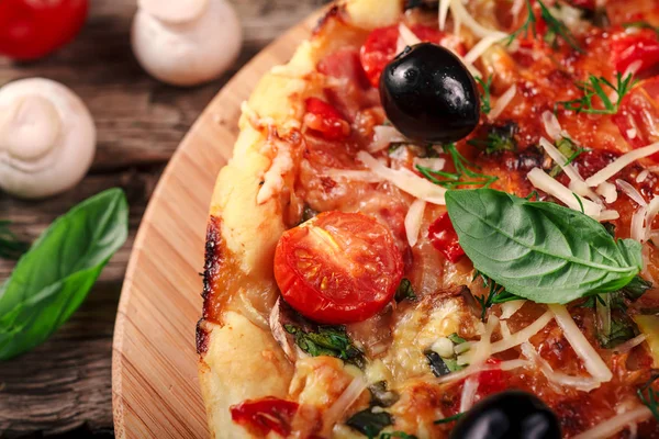 Tahta masada domatesli, peynirli ve mantarlı taze pizza.