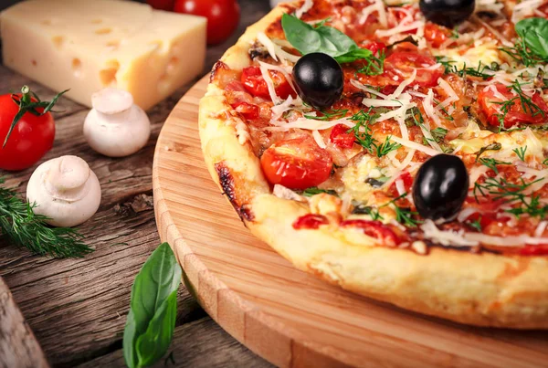 Tahta masada domatesli, peynirli ve mantarlı taze pizza.