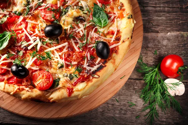 Tahta masada domatesli, peynirli ve mantarlı taze pizza.