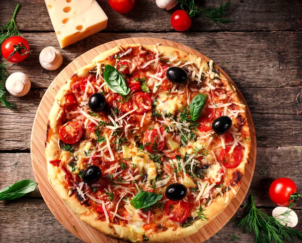 Tahta masada domatesli, peynirli ve mantarlı taze pizza.