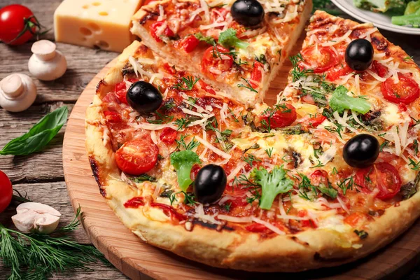 Tahta masada domatesli, peynirli ve mantarlı taze pizza.