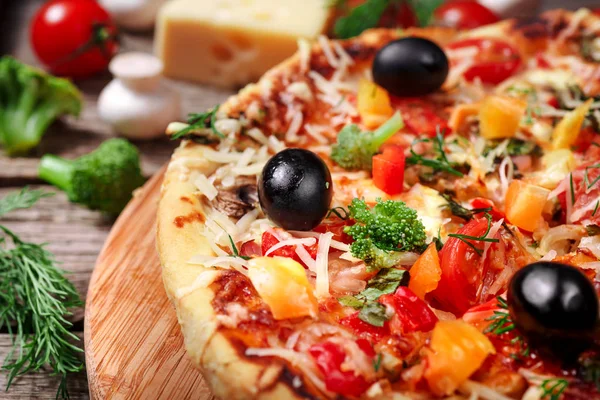 Tahta masada domatesli, peynirli ve mantarlı taze pizza.