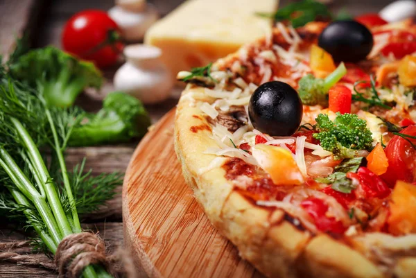 Tahta masada domatesli, peynirli ve mantarlı taze pizza.