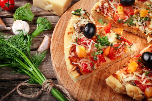 Tahta masada domatesli, peynirli ve mantarlı taze pizza.