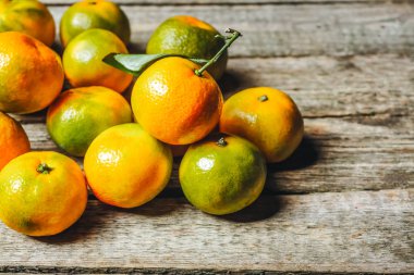 Ahşap zemin üzerinde bir sürü taze mandalina veya mandarine yeşil yapraklar
