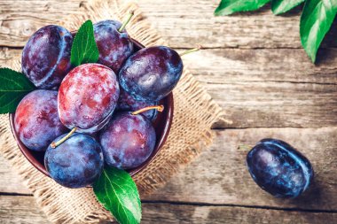 Ahşap masa üzerinde mavi ve mor Erik