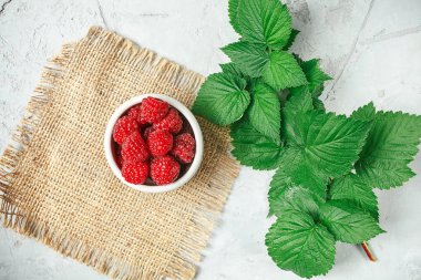 Beyaz rustik ahşap arka plan üzerinde kırmızı taze ahududu. İle kase