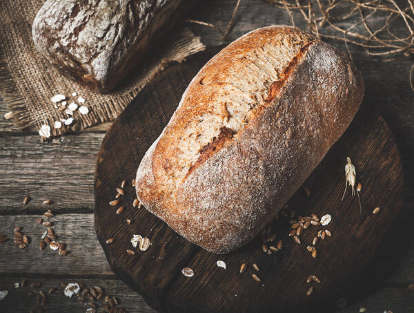 Rustic bread and wheat on an old vintage planked wood table. Dar