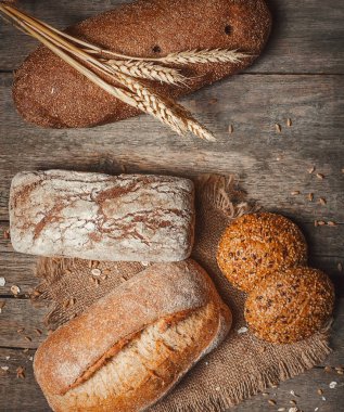 rustik tarzı retro arka planda ekmek. Bir çuval un ile ahşap zemin üzerinde taze geleneksel ekmek