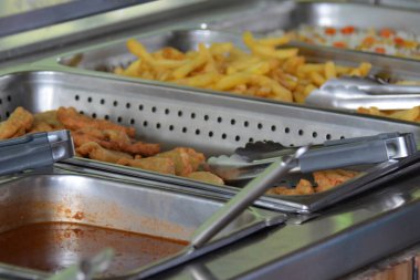 Mezar, sebze ve patates kızartması servis büfesinde, tepsilerle.