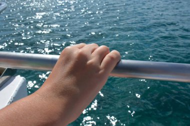 Çocuğun eli parmaklıklarda, yatta.