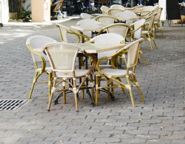 İyi havada kaldırımda bir sıra hasır sandalye.