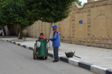 CAIRO / EGYPT - ARALIK 06, 2018: Bir tramvayla daha temiz ve çöp dolu bir sepet ve küçük bir çocuk