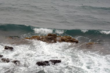Koyu fırtınalı deniz taşlı ve köpüklü