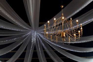 Düğün dekorunun arka planında güzel altın bir avize.