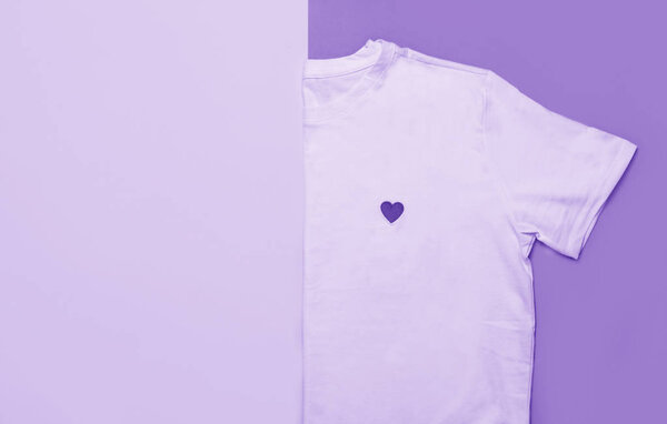 Вид сверху белой женской футболки на розовом и желтом фоне. Ж
