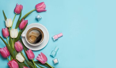 iki bardak kahve ve Pembe Lale mavi zemin üzerine. Günaydın kelime. Bahar kahve kavramı. Üstten Görünüm, düz yatıyordu