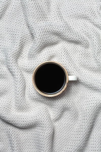 Filiżanka kawy na tle wełny. Widok płaski świeckich, top. Sweter z dzianiny tekstury. — Zdjęcie stockowe