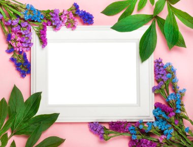 pembe bir arka plan üzerinde beyaz ahşap çerçeve yeşil yaprakları, bir metin için boş alan ile dekore edilmiştir. Üstten Görünüm, düz yatıyordu