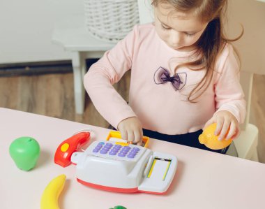 Oyuncak Dükkanı ile oynarken küçük güzel bir kız. eğitim süreci