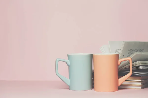 Nahaufnahme von zwei Tassen und einem Buch auf rosa Hintergrund. Kopierraum für Ihren Text oder Ihr Design — Stockfoto